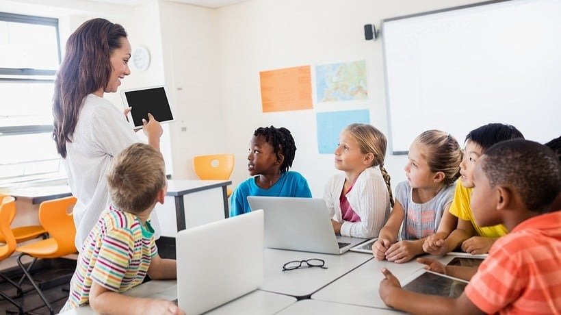 Teacher presenting with a tablet to engaged students